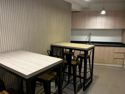 Sala común con cocina y mesones altos en el estudio Código Music
