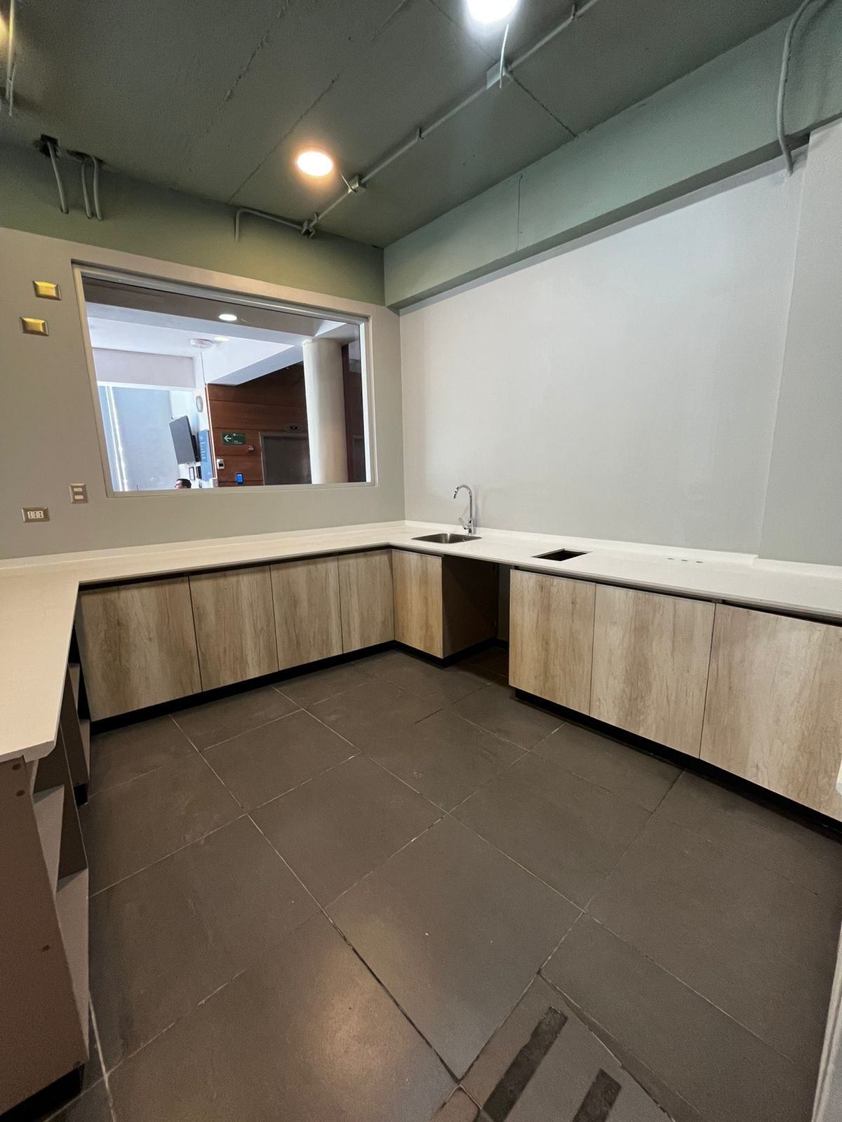 Área de servicio de la cafetería con mesón y muebles instalados, PUCV