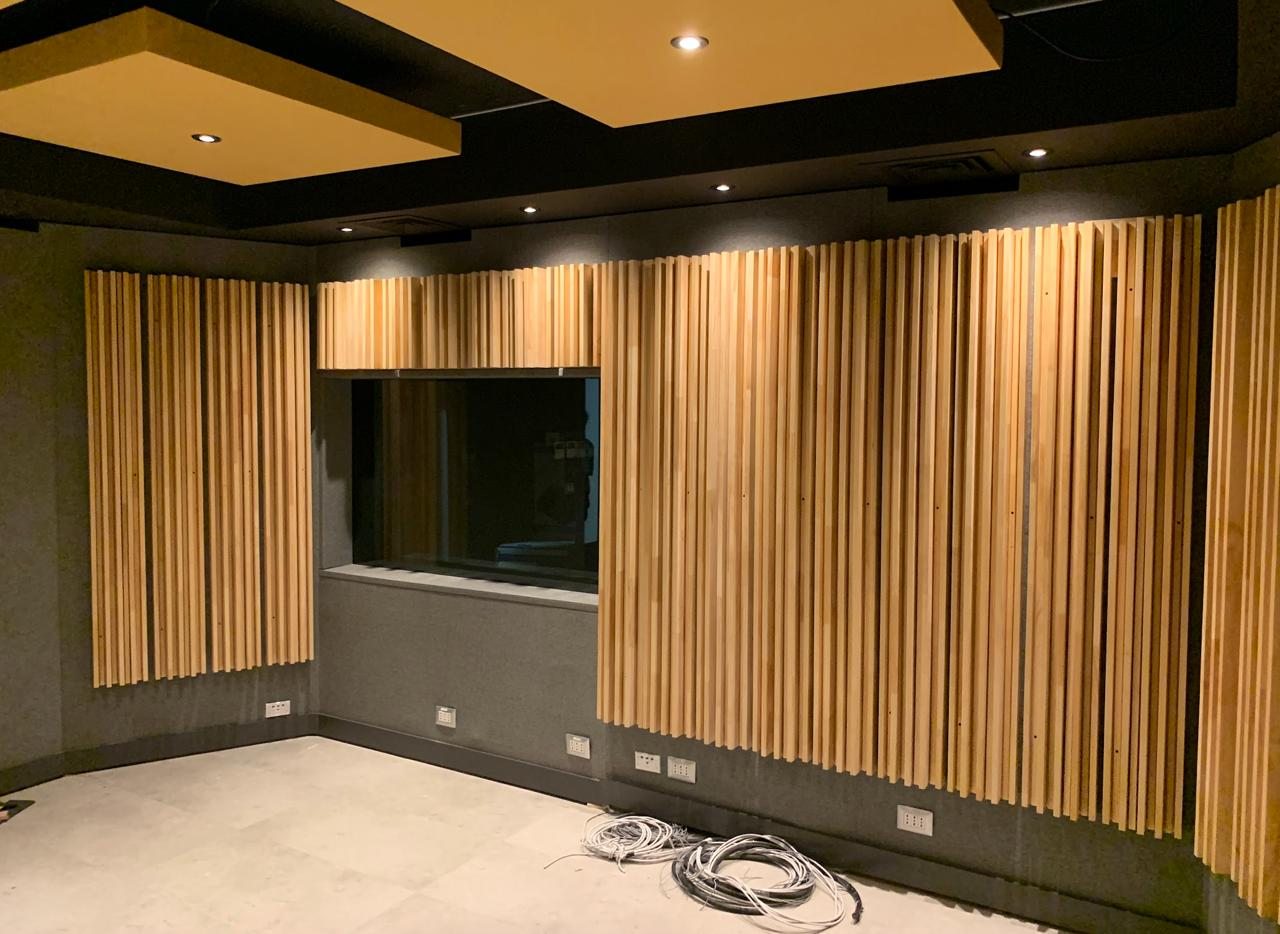 Muro de listones de madera y ventana de control de la sala de grabación, Warner Music Chile